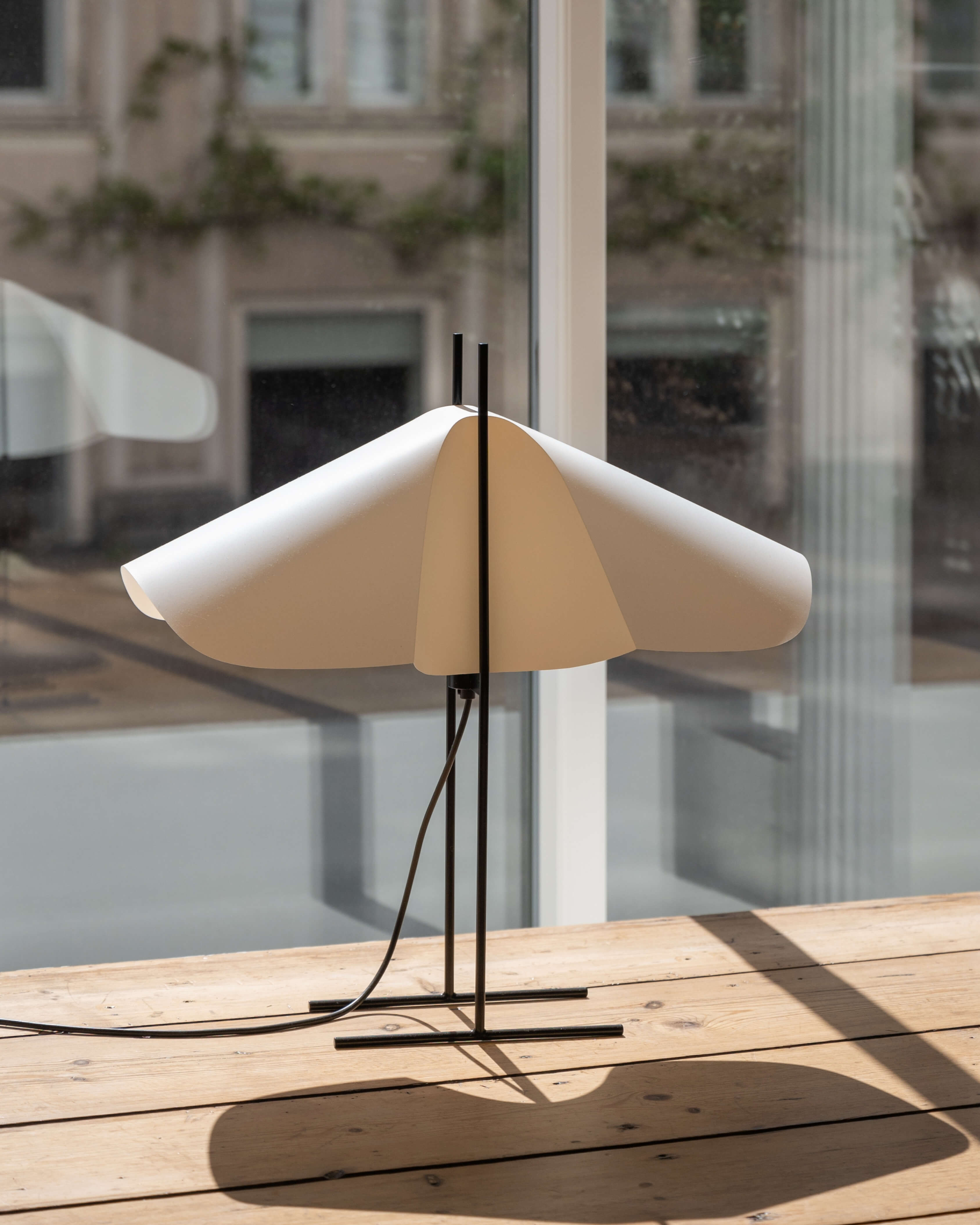 Cho floor lamp in translucent PVC with black steel base and light off, styled in a modern interior by Motarasu