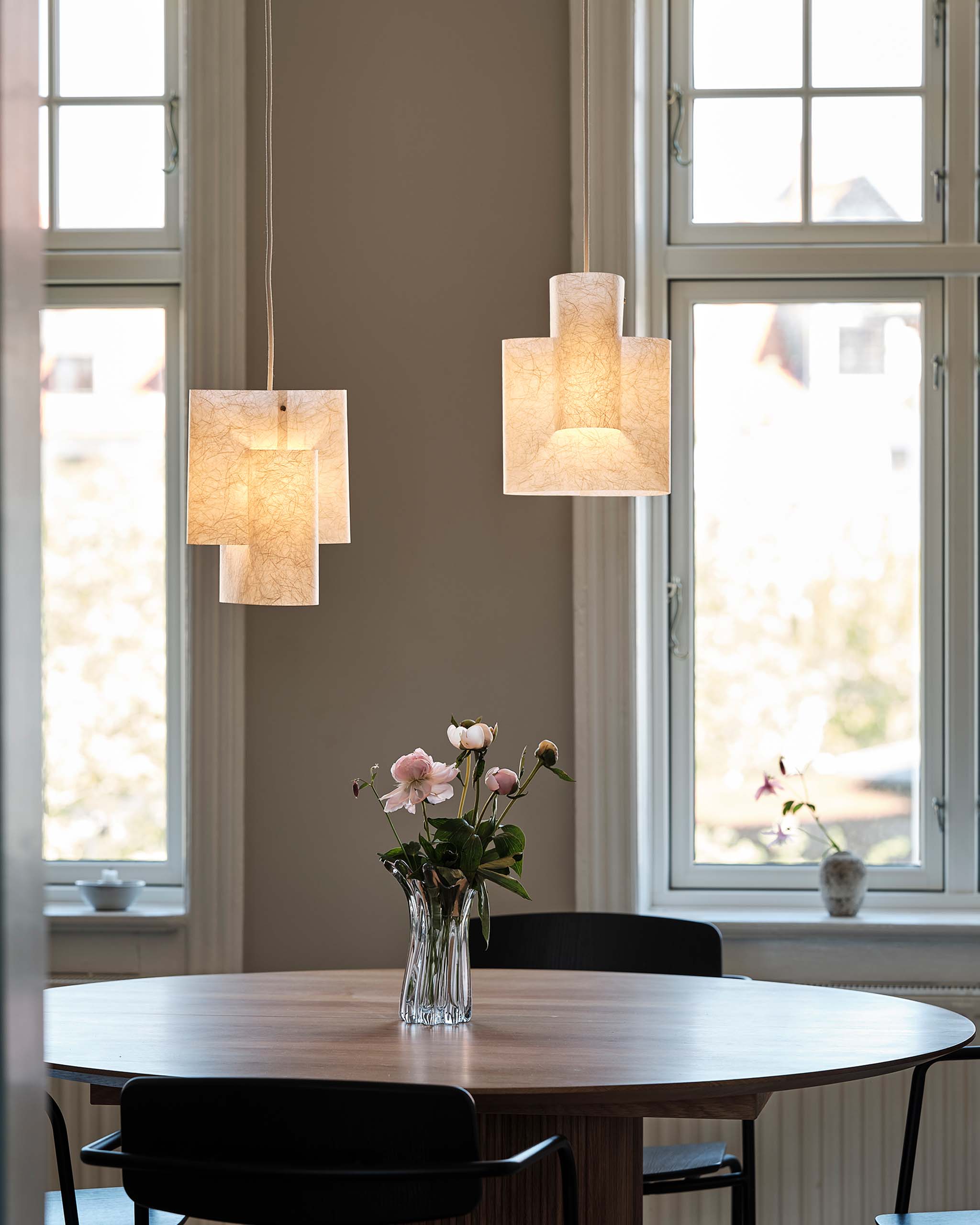 Sekiun washi paper textured modern multi-tiered cylindrical pendant lights with textured beige paper over a round wooden dining table