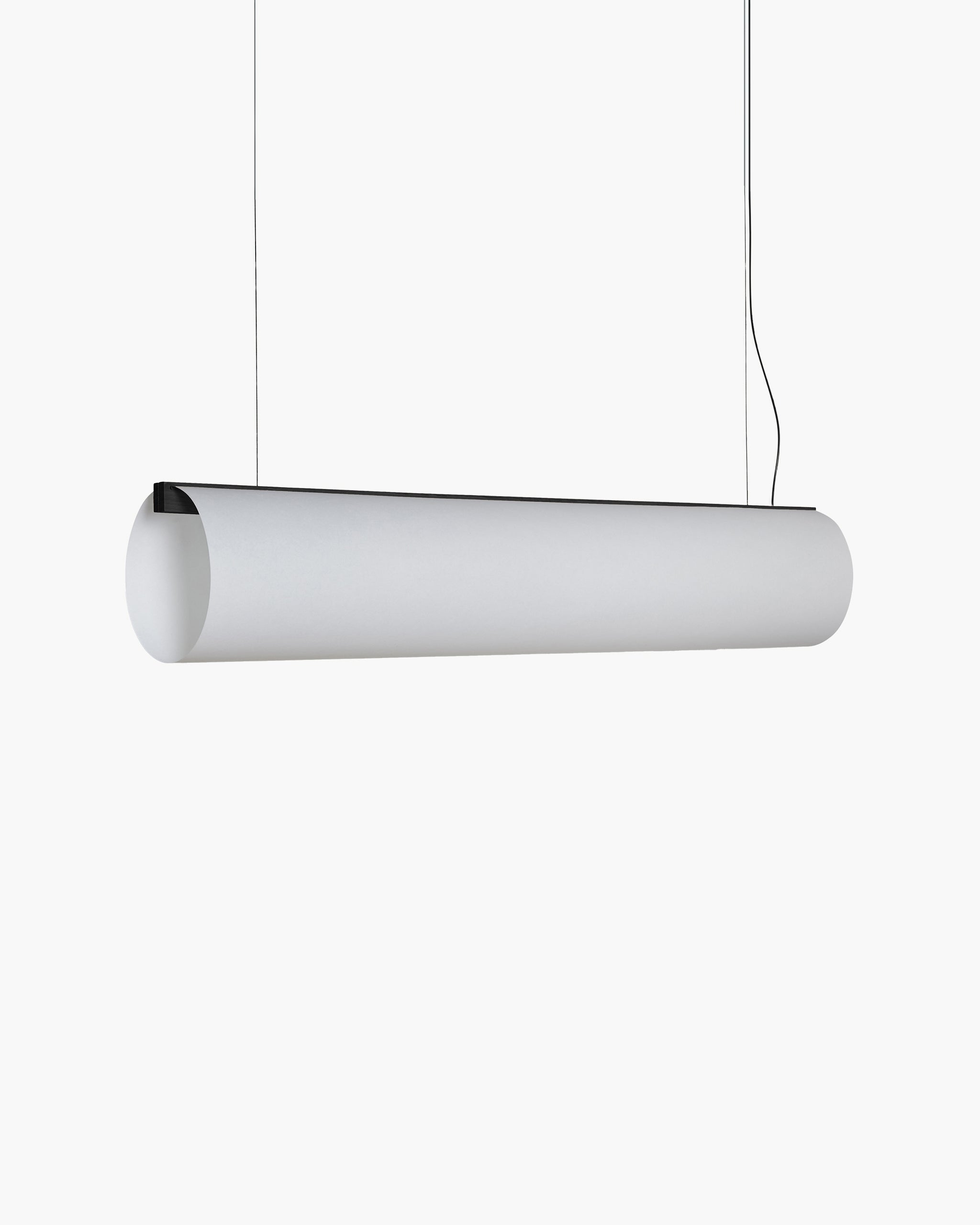 A modern cylindrical pendant light fixture in matte white, suspended by thin black cords against a solid white background.