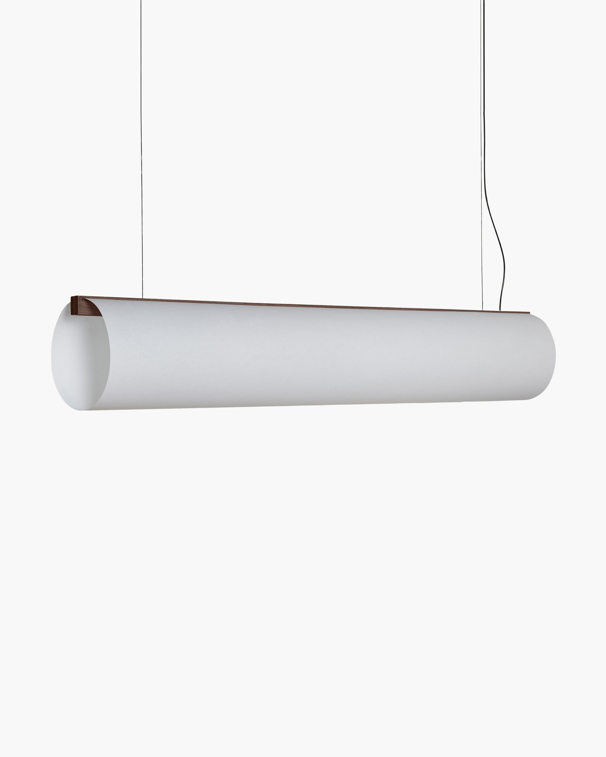 A modern cylindrical pendant light fixture with a matte white cylindrical shade and a thin dark brown wooden top rim, suspended by thin black cords against a solid white background.