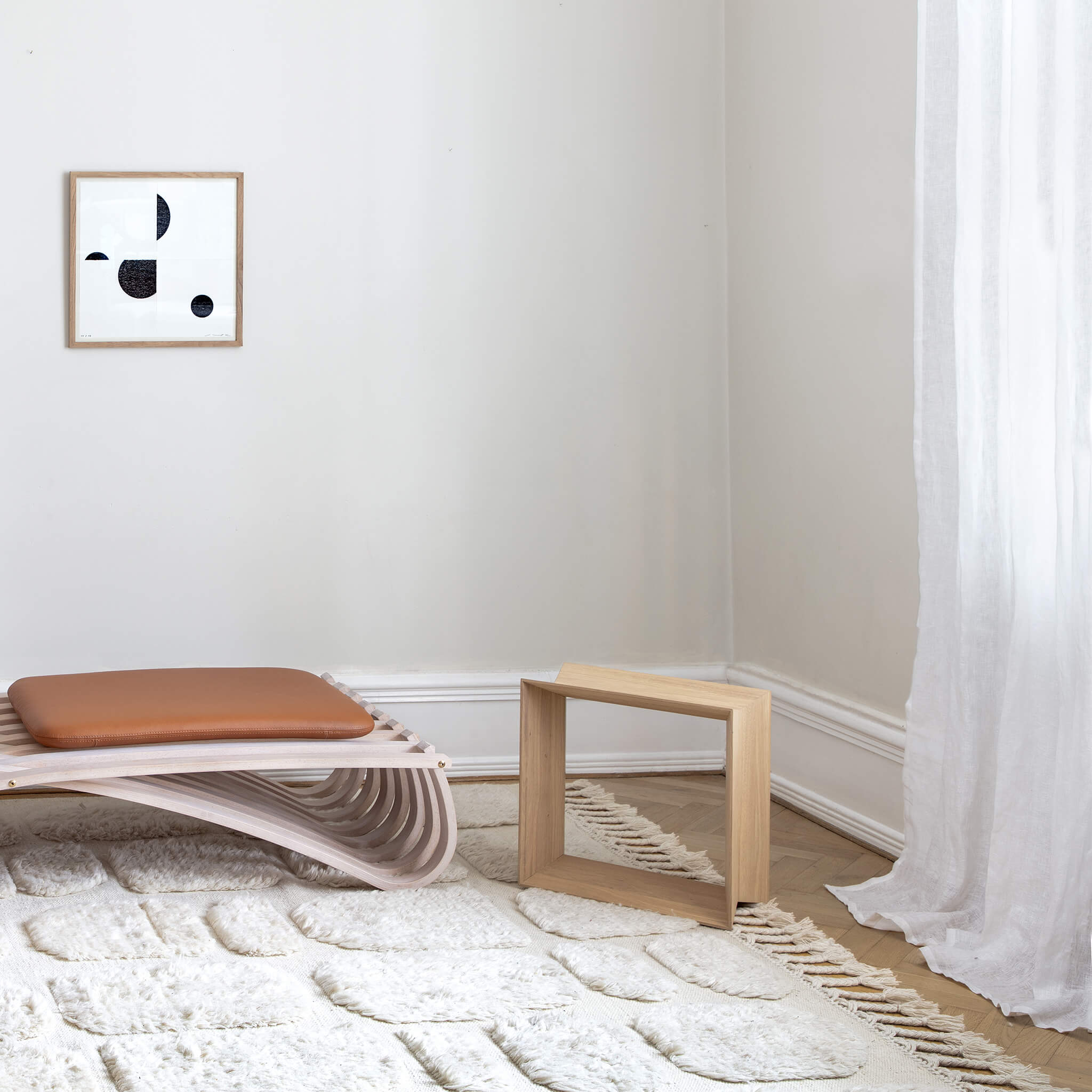 Light brown oak stool placed in a home, on a white carpet