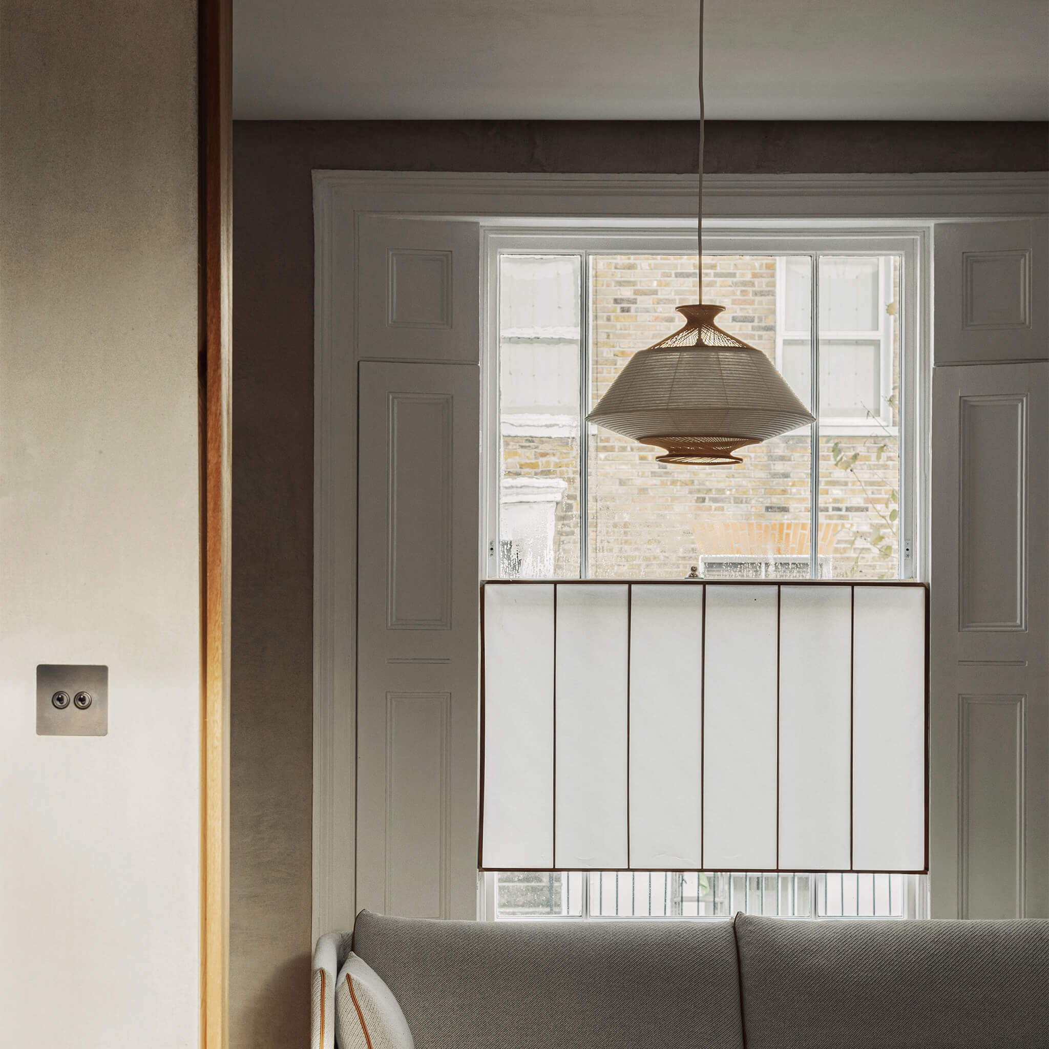 Pendant light placed by the window, above the couch