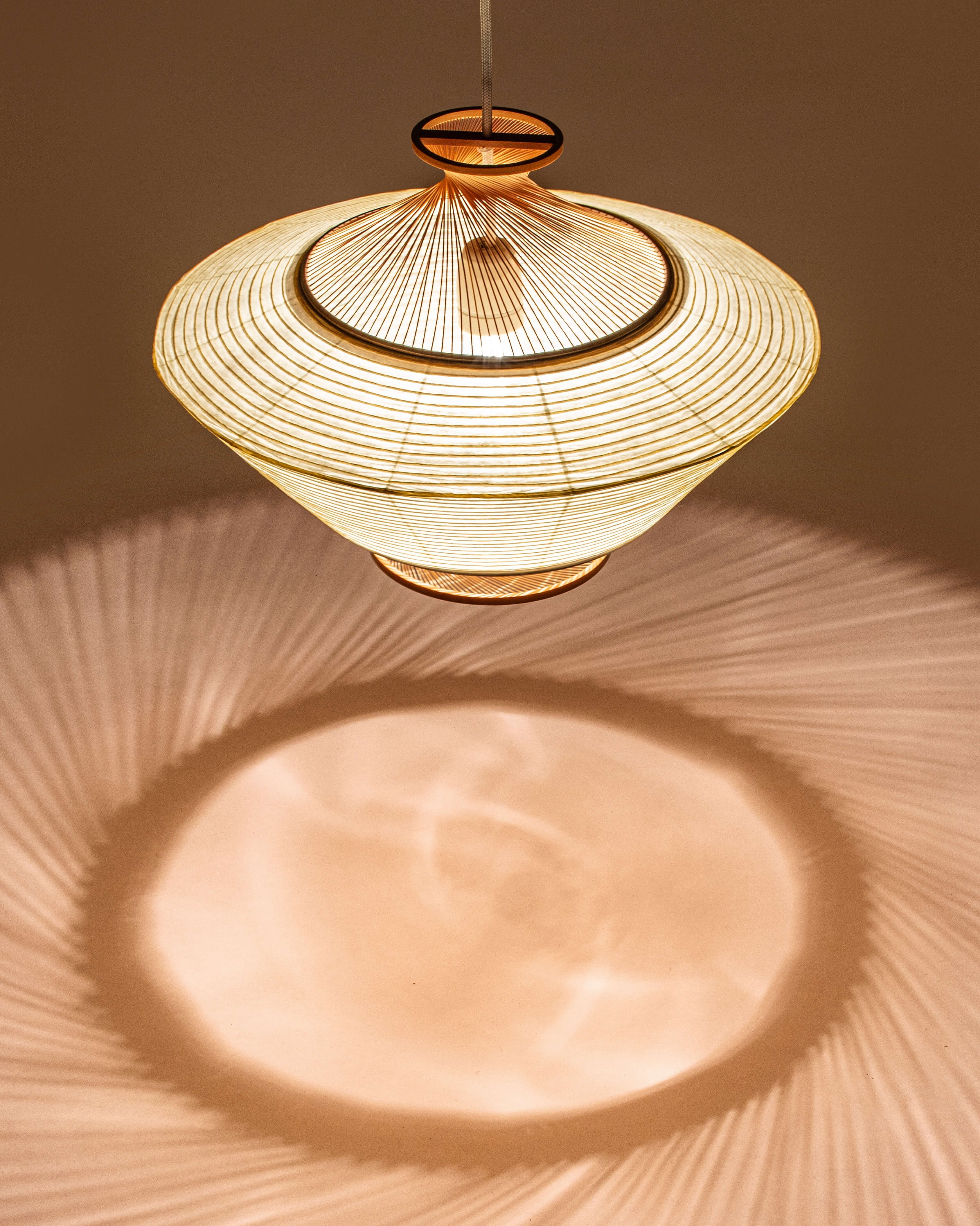 Ron pendant in washi paper and Hiba wood, close-up of bamboo texture and warm light on brown background by Motarasu