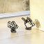 Two black coated steel sculptures placed on the floor, casting their shadows