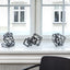 Collection of three steel sculptures, coated in black, placed on a window seal