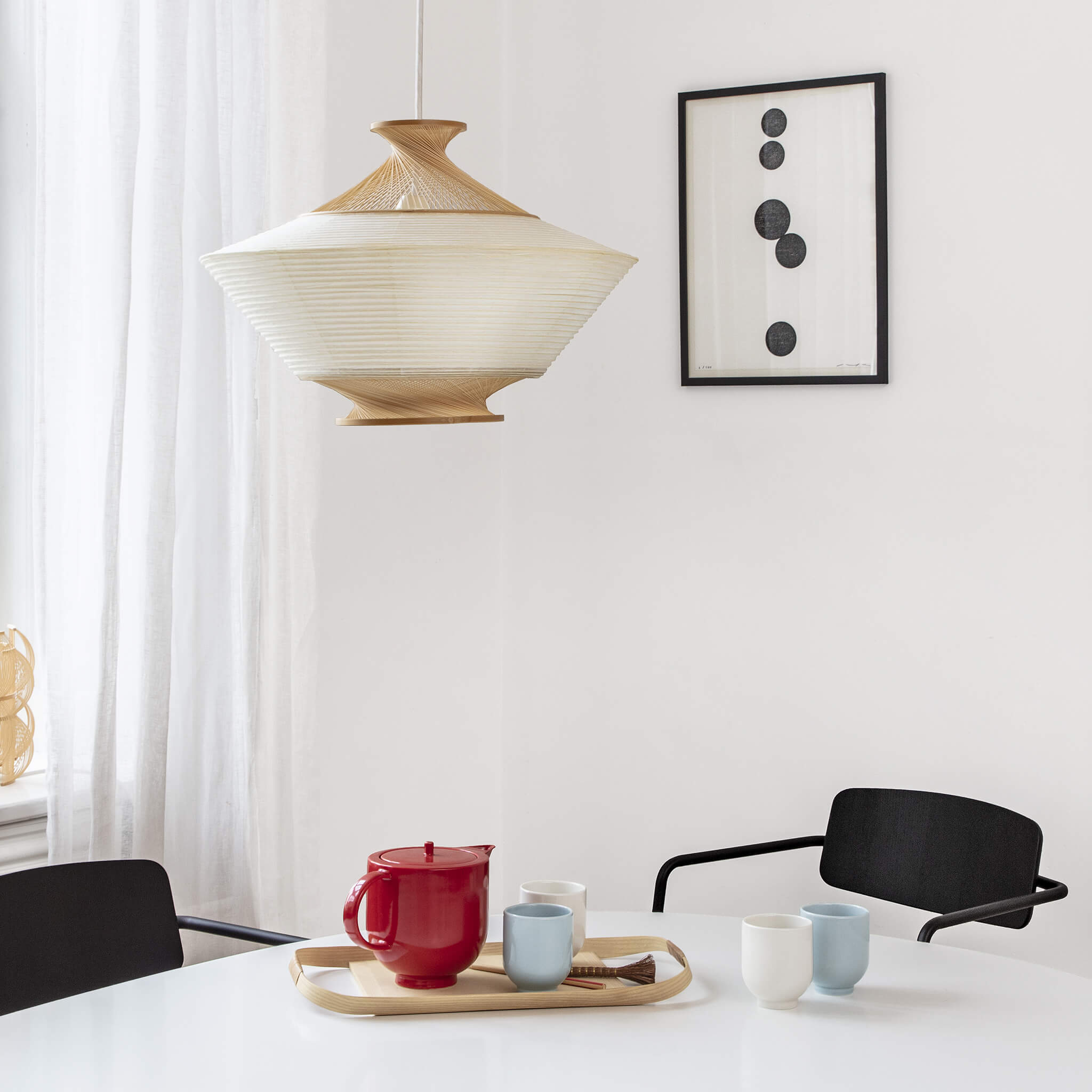 Four tea mugs and a teapot placed on a dining table