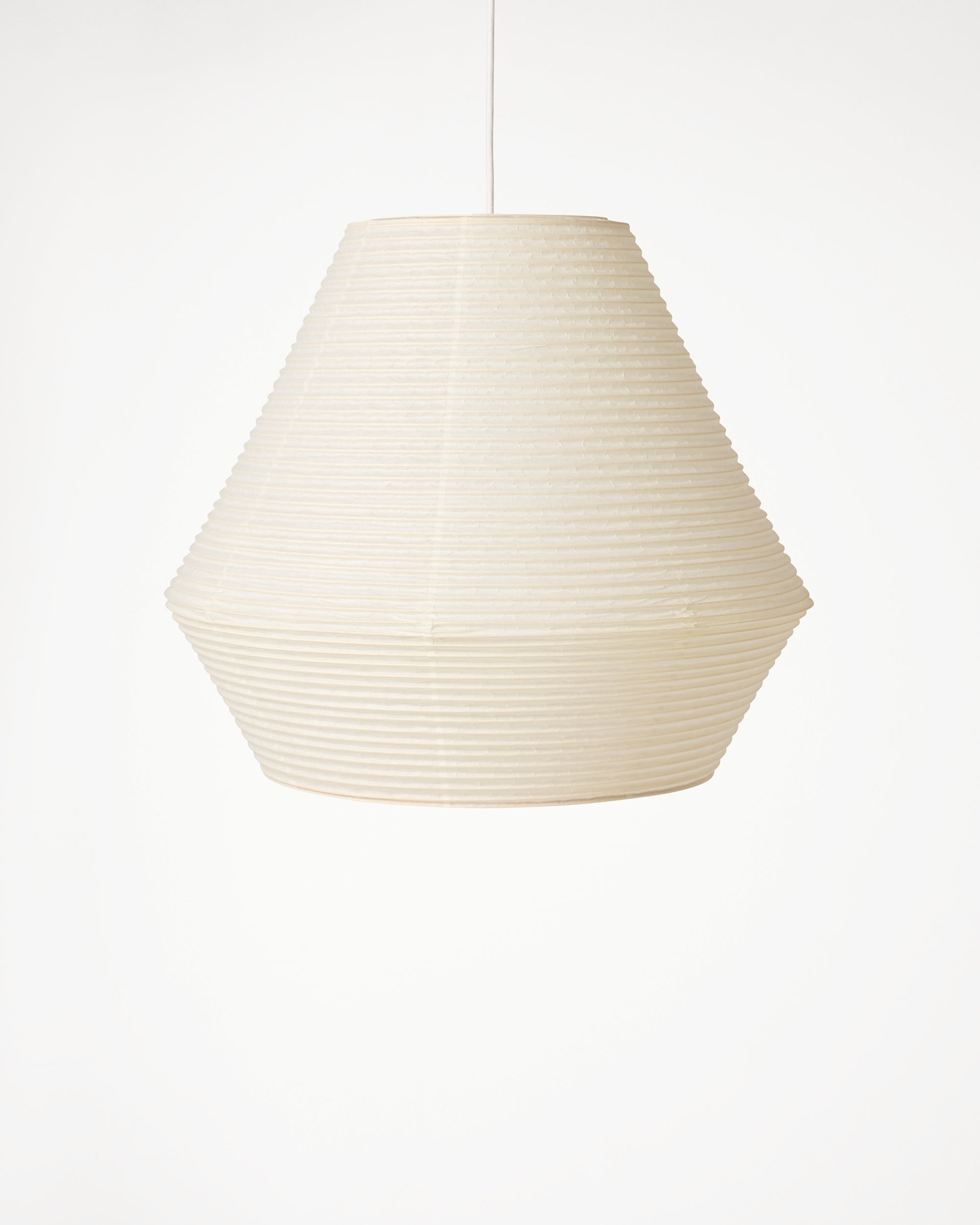 An off-white paper lantern pendant light with a ribbed, pleated texture, suspended by a thin cord against a plain white background.