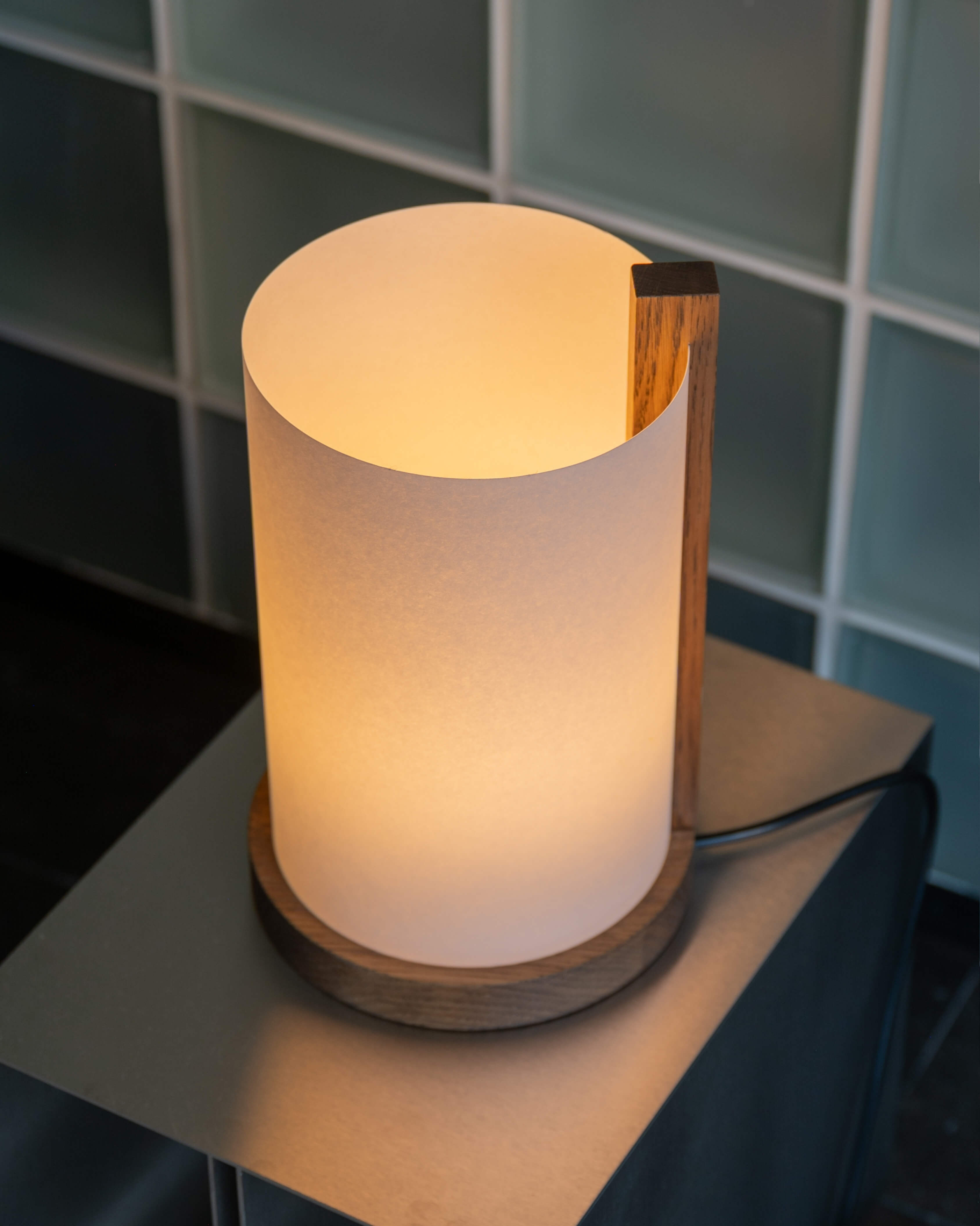 Enso table lamp in washi paper and oak, styled on a nightstand in a modern bedroom by Motarasu