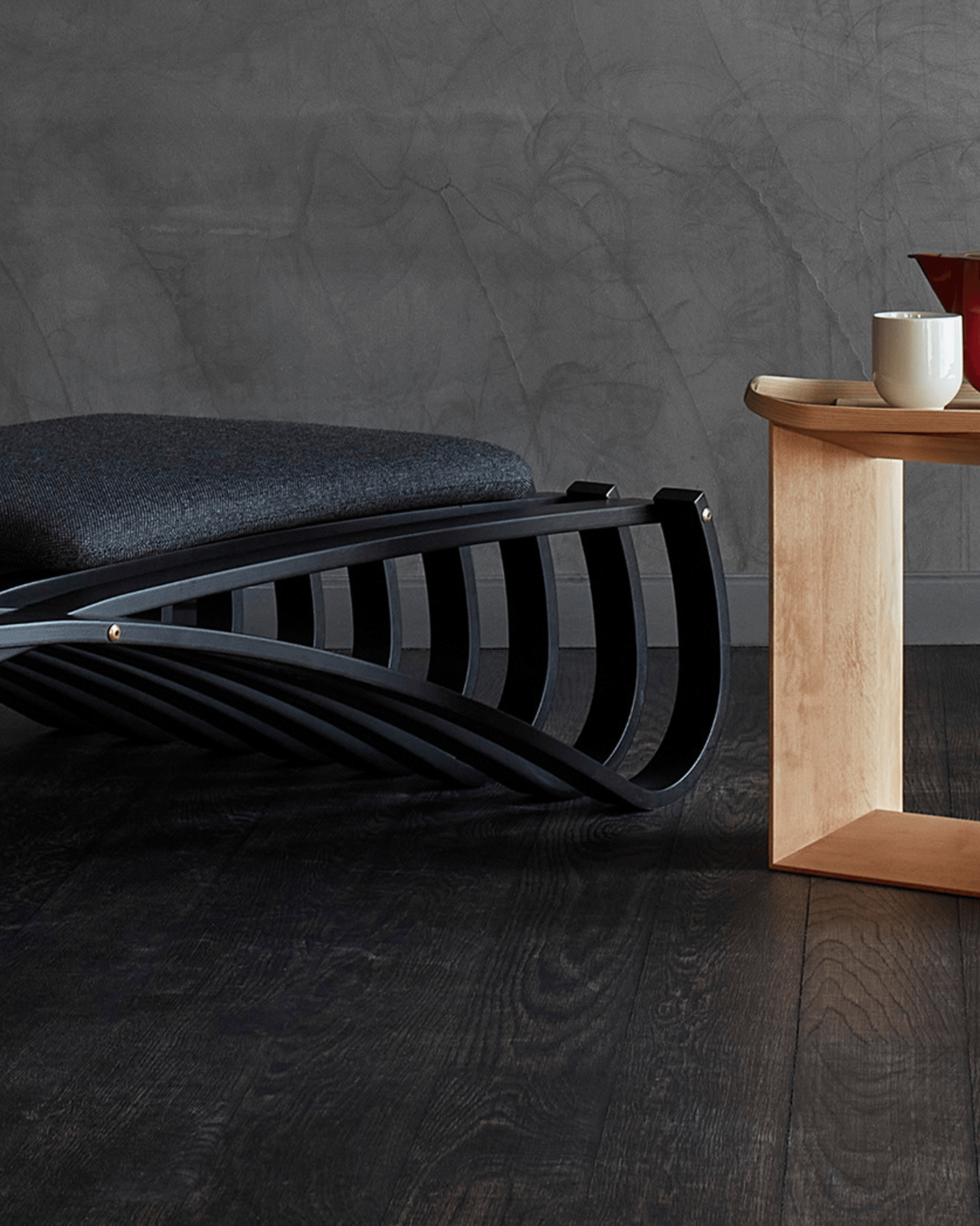 Jundo daybed in black matt beech veneer with black cushion, styled in a dark interior by Motarasu