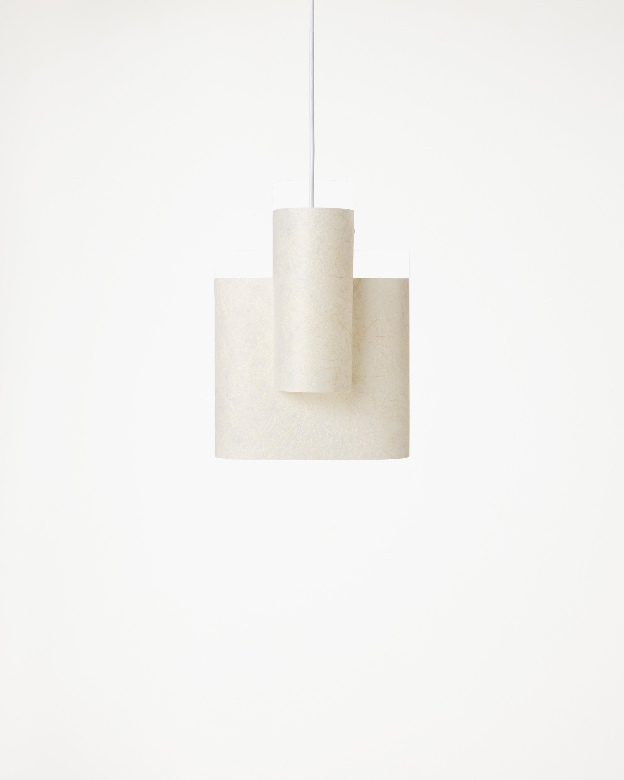 Sekiun Raw textured washi paper pendant lamp by Ryota Yokozeki, lit above a dining table