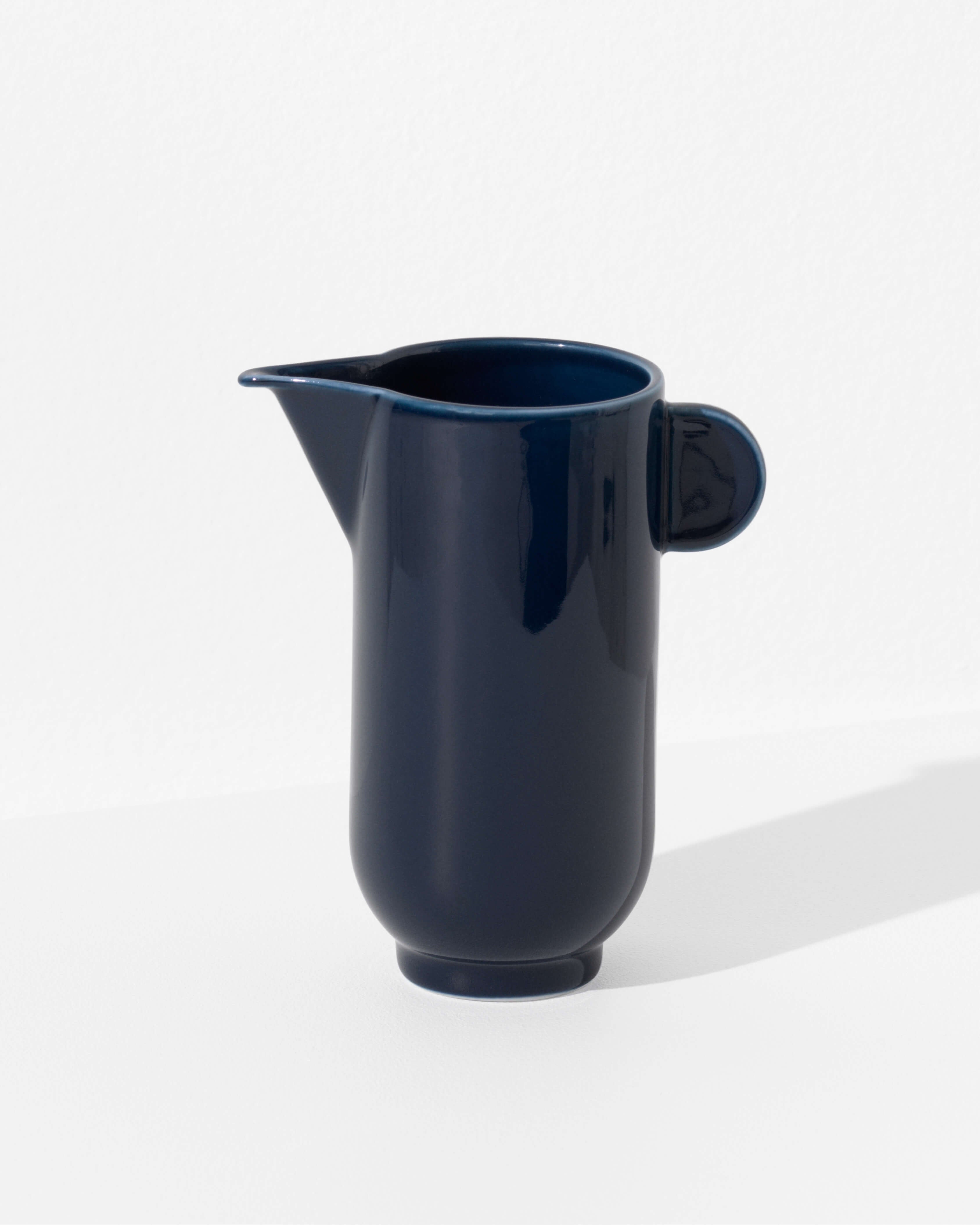 Yoko pitcher in dark navy blue porcelain, full silhouette on white background by Motarasu