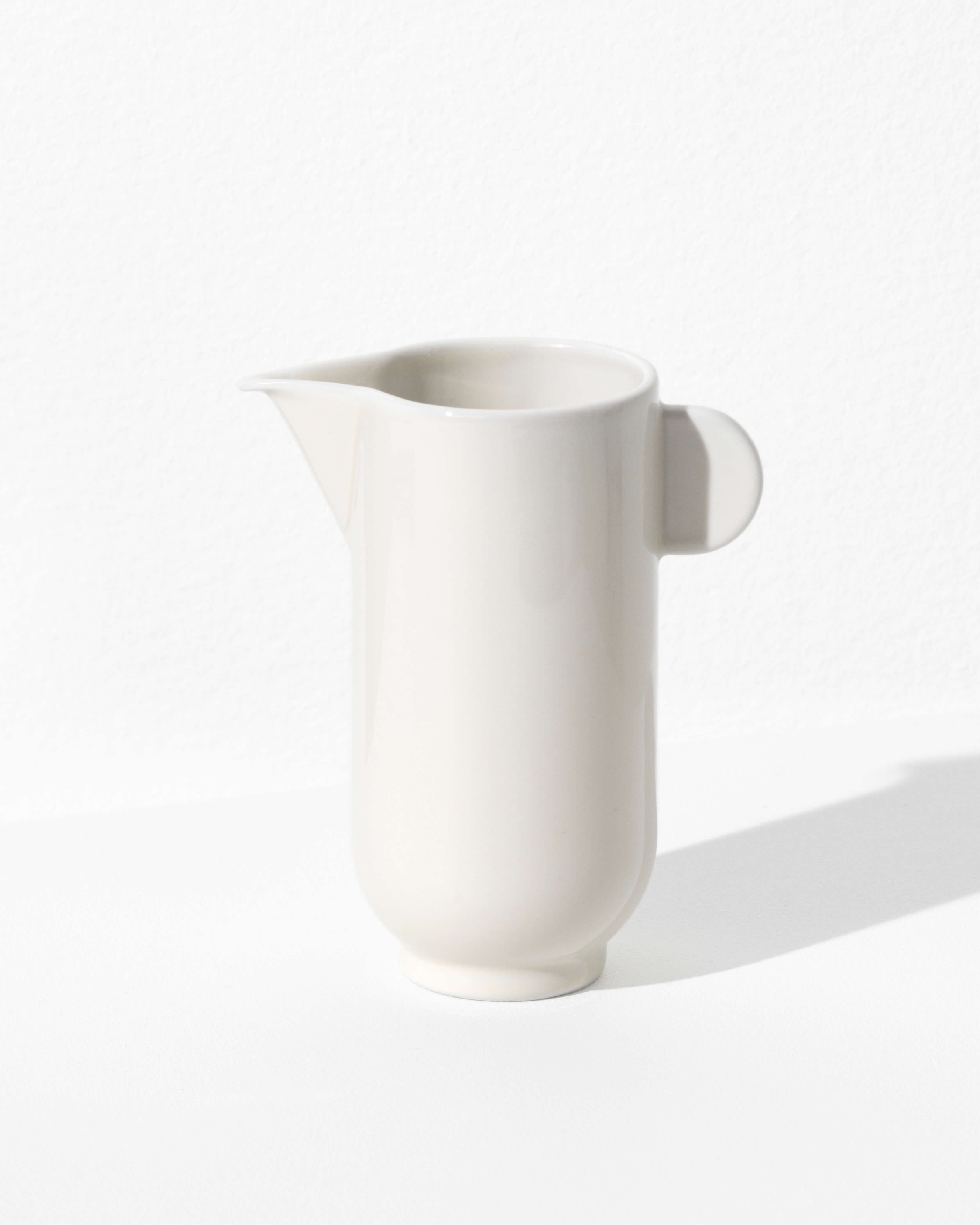 Yoko pitcher in eggshell white porcelain, full silhouette on white background by Motarasu