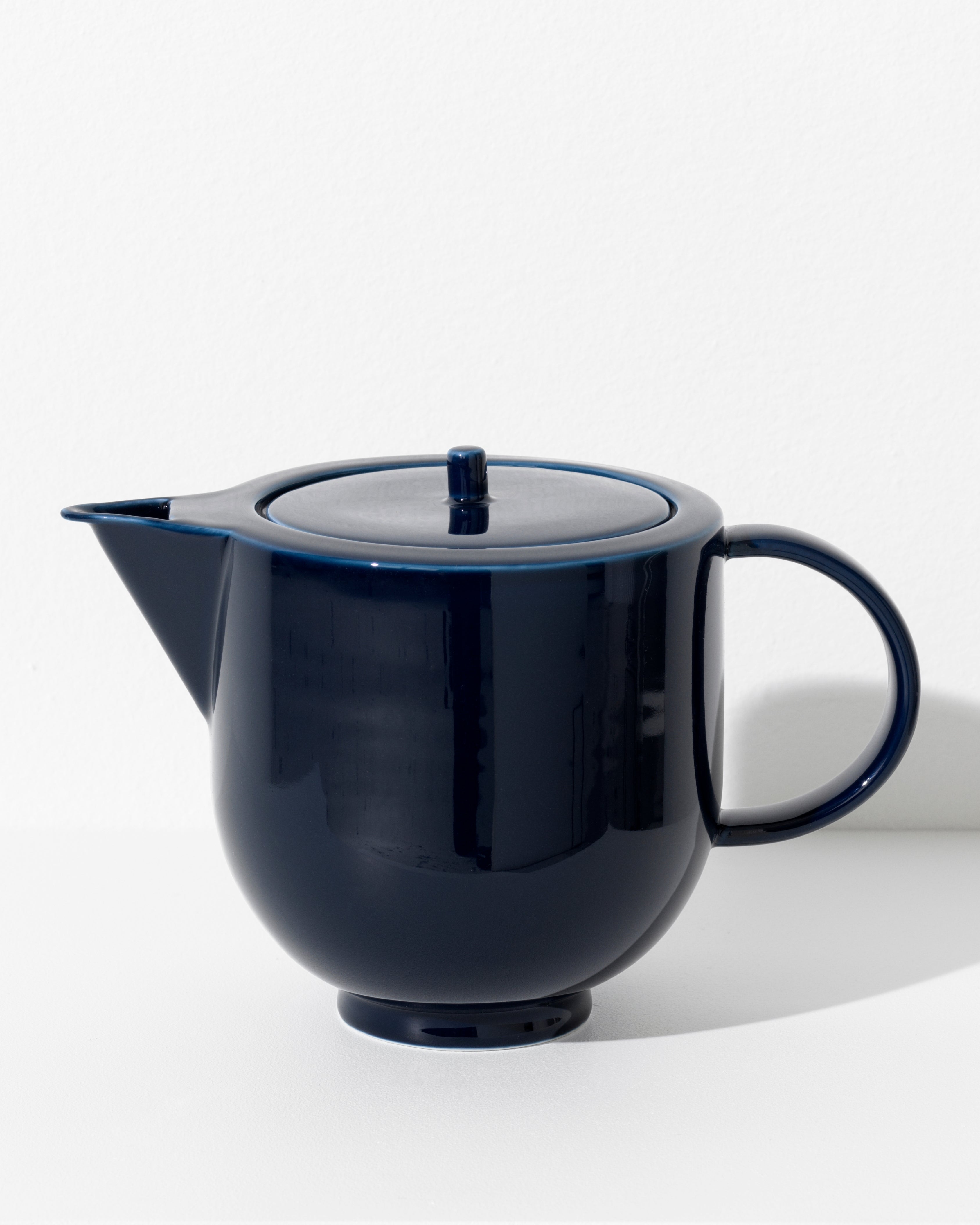 Yoko teapot in dark navy blue porcelain, full silhouette on white background by Motarasu